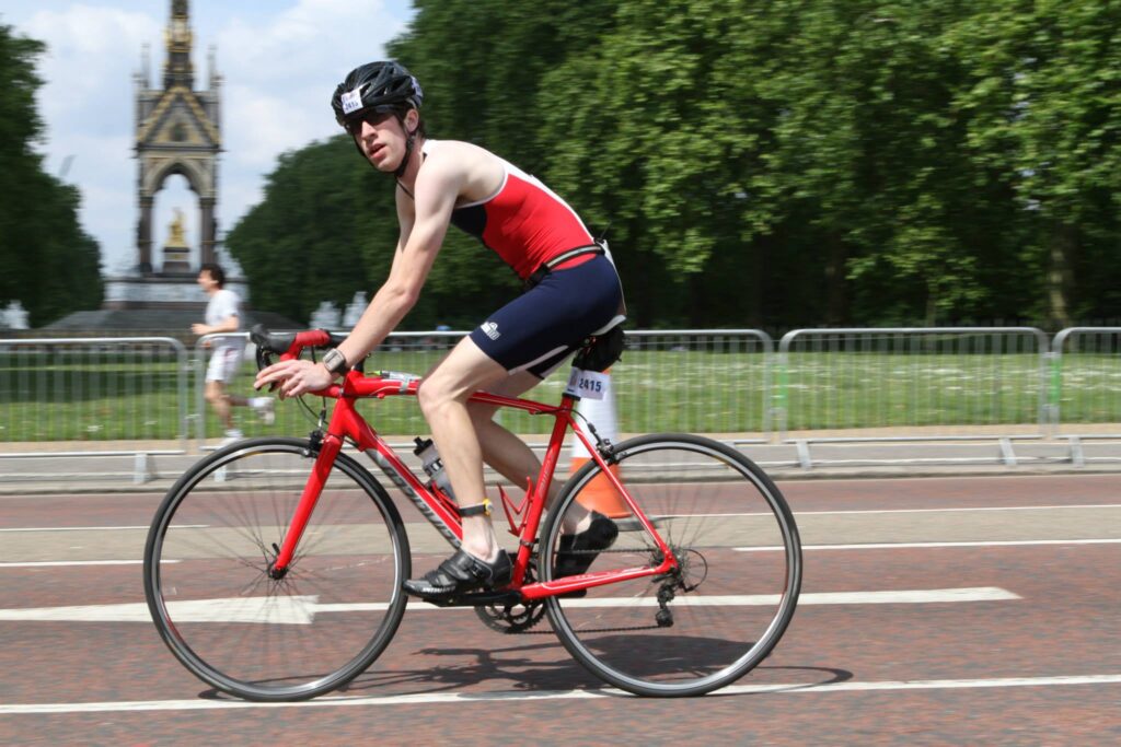 A triathlete riding on the best budget triathlon bike they could afford at the time