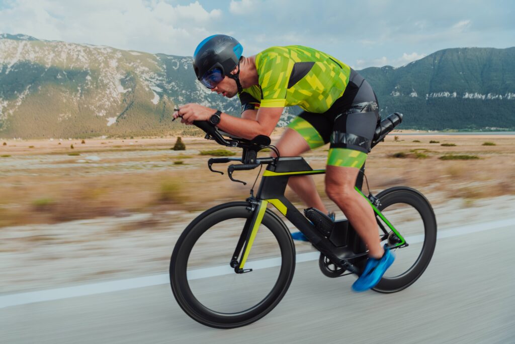 A triathlete cycling against the mountains, most likely racing in a 70.3 distance triathlon